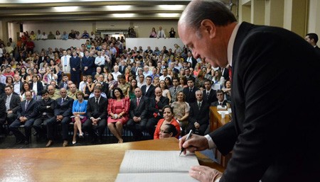 Schirmer assinando o documento de posse, a foto também publicada no feicebuqui